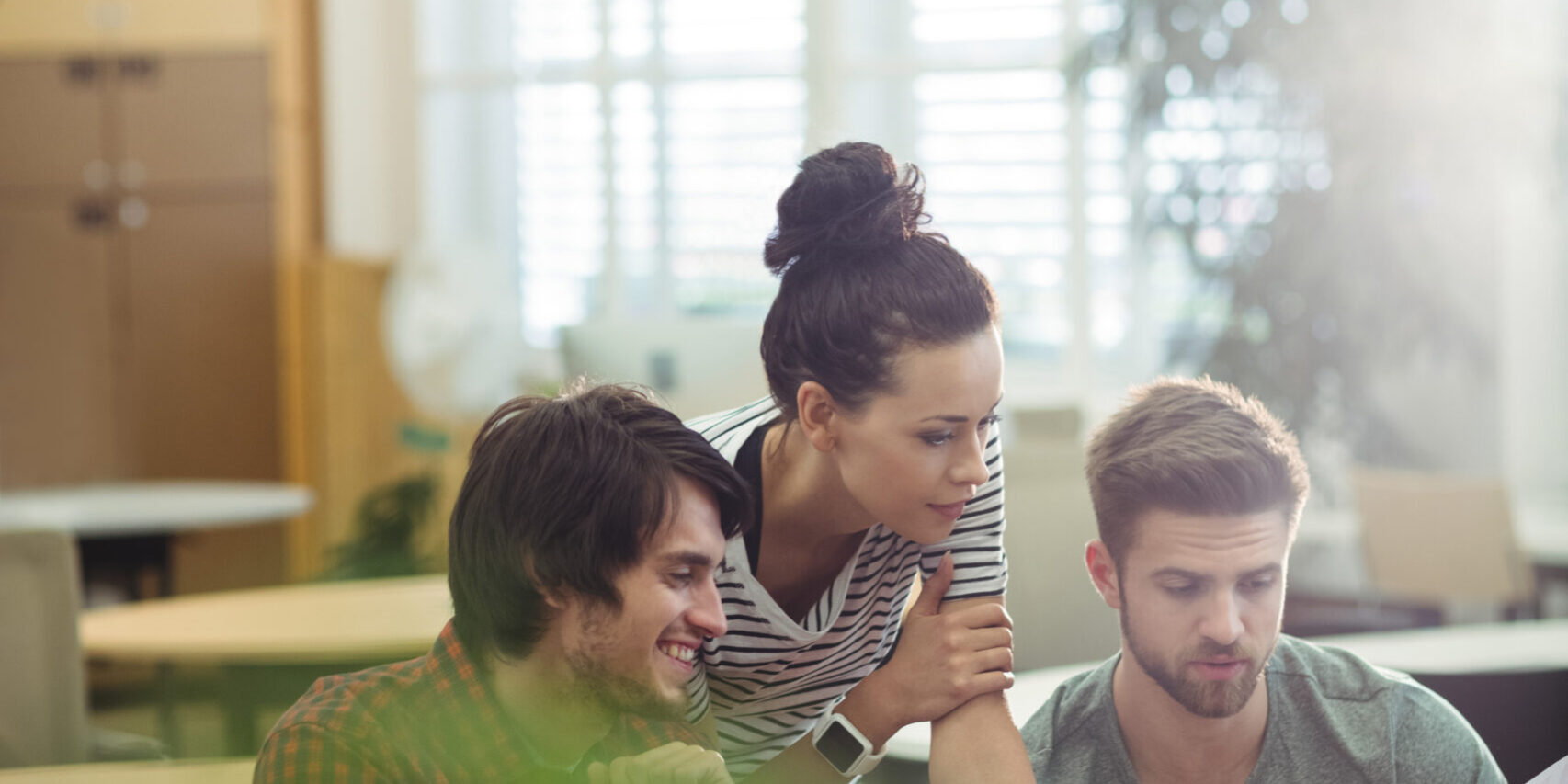 Group of business executives discussing over laptop at their desk